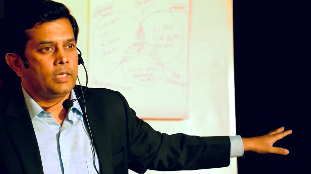 Raam Anand teaching at a whiteboard